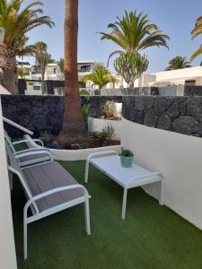 科斯塔特吉塞Bungalow Paseo del Mar- PLAYA ROCA Residence sea front access - Free AC - Wifi的庭院里摆放着一组椅子和一张桌子