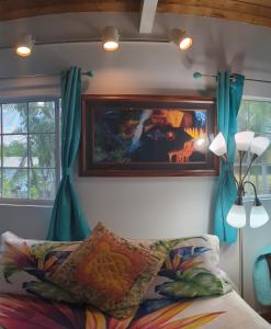 希洛Hilo Luxury Suite的卧室配有一张床,墙上挂有绘画作品