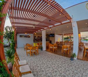 伊察Hotel La Colina的餐厅里设有木凉亭,配有桌椅