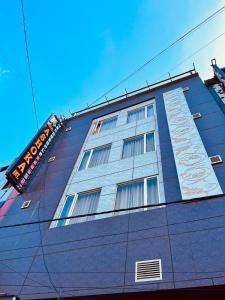 新德里Ashoka International Hotel - Karol Bagh New Delhi的蓝色的建筑,旁边标有标志