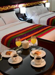阿亚库乔Altipacha Ayacucho Hotel的一间设有一张桌子和两杯葡萄酒的房间