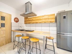 卢布林Gościnnie Lublin - Olimp的厨房配有带凳子的柜台和冰箱。