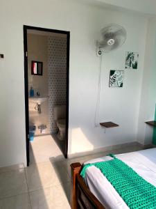 帕洛米诺Casa Guiwa Hostel的一间带一张床的卧室和一间带风扇的浴室