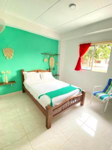 帕洛米诺Casa Guiwa Hostel的一间卧室设有一张床和绿色的墙壁