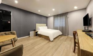 统营市Hotel Laon的酒店客房配有一张床、一张书桌和一台电视。
