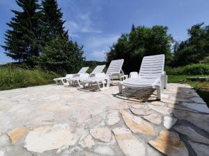 普利特维采湖Vacation House Home, Plitvice Lakes National Park的石头庭院里一排白色椅子