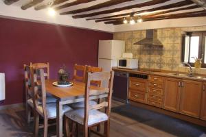 锡德自由镇Casa Rústica y vistas a la montaña - Els Llavadors的厨房配有桌椅和冰箱。