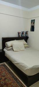 阿莱曼الساحل الشمالي的卧室内的一张带白色床单和枕头的床