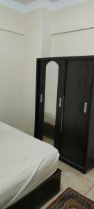 阿莱曼الساحل الشمالي的一张带黑色框架和镜子的床