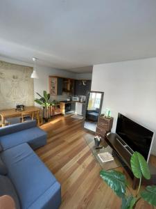 布鲁塞尔Appartement spacieux pour un séjour inoubliable的一间带蓝色沙发的客厅和一间厨房