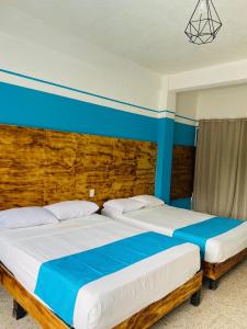 阿卡普尔科Hotel Lu Acapulco的卧室内两张并排的床