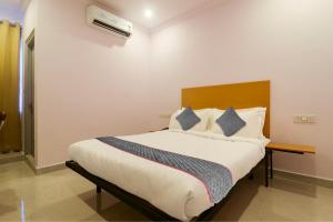 海得拉巴Townhouse Rcc Premier Sr Nagar的一间卧室配有一张大床和木制床头板