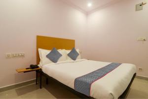 海得拉巴Townhouse Rcc Premier Sr Nagar的卧室配有带蓝色枕头的大型白色床