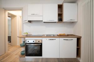 阿莱盖SnowLake Suite & Apartment的厨房配有白色橱柜和炉灶。