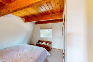格罗夫兰Cozy Cabin的一间卧室设有一张床和木制天花板