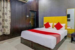 勒克瑙OYO Flagship Ideal Inn的一间卧室配有一张带红色枕头的大床