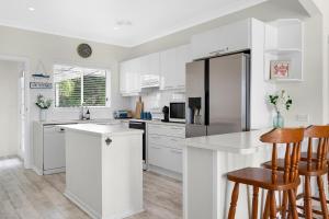 文森提亚AXL Orion Beach Home: Beach front的白色的厨房配有白色橱柜和冰箱。