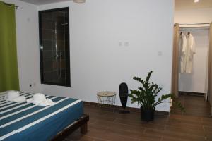 MatouryVilla Perle - 2 suites的一间卧室配有一张床和盆栽植物