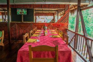 AguaricoCaiman Eco Lodge的一间长长的用餐室,配有桌椅