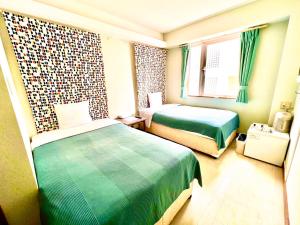 石垣岛石垣幸福假日酒店的酒店客房设有两张床和窗户。