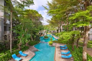 努沙杜瓦巴厘岛努沙杜瓦万怡度假酒店的一张带椅子和树木的度假游泳池的图片