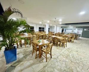 科韦尼亚斯Hotel Playarena的餐厅设有木桌和椅子,种有植物