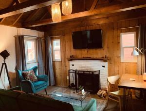 赖特伍德Grand Pine Cabins的客厅设有壁炉和墙上的电视