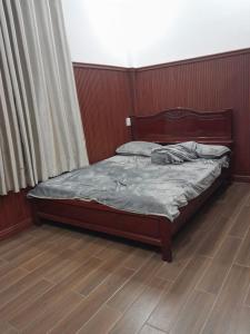 Long AnPhụng Kim Thảo Hotel Long An的卧室内的一张床位,铺有木地板