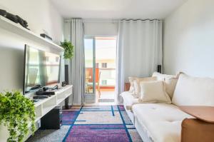 阿拉亚尔-杜卡布Arraial Golden Lake Residence的客厅配有白色沙发和电视