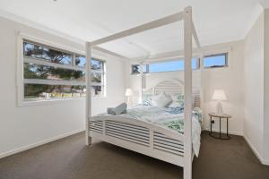 卡尔斯Hazelwood的卧室配有白色的床和窗户。