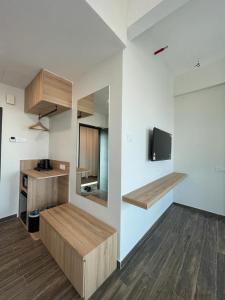 瓜拉丁加奴DJ Citi Plaza Hotel & Suites的客房拥有白色的墙壁、木制家具和电视。