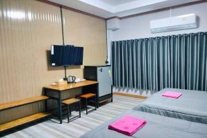Ban Non KumPingpong Place的客房设有两张床和一张书桌及一台电视。