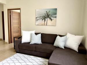 塔穆宁Tumon Isa 16 Condo的客厅配有棕色的沙发和棕榈树