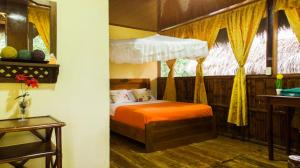 AguaricoCaiman Eco Lodge的一间卧室配有一张带橙色床罩的床