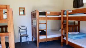 特卡波湖Lakes Edge Lodge的带三张双层床和椅子的房间