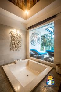 八丹拜Villa Black Pearl - by Unicorn Villas Bali的窗户客房内的大浴缸