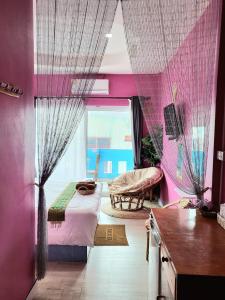 格兰岛บ้านเนวี่ เกาะล้าน的卧室设有粉红色的墙壁、一张床和窗户