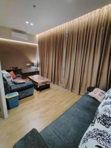 Kota SamarahanSummer Mall Summer Suite 2 bedroom unit的一间带两张床和一张沙发的客厅