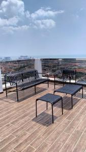 TranquerahThe Quartz 3 Bedroom Apartment with fully furnish and fully aircond, infinity pool, Corner lot with seaview and city view centre of malacca city的坐在屋顶上的一组长椅