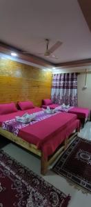 帕罗林ALEGRO HOLIDAY HOMES的一间卧室配有一张带粉红色床单的大床
