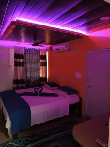 帕罗林ALEGRO HOLIDAY HOMES的一间设有紫色灯床的房间