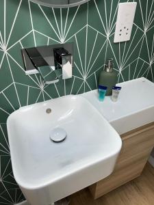 布莱顿霍夫Central ensuite guest unit with free on-street parking的浴室设有白色水槽和绿色的墙壁