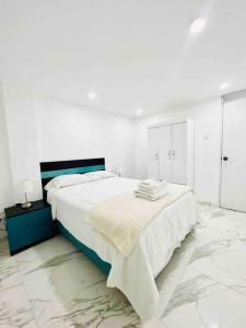 利马Departamento La Punta E - Piscina - Zona parrilla的白色卧室配有一张带蓝色床头板的大床