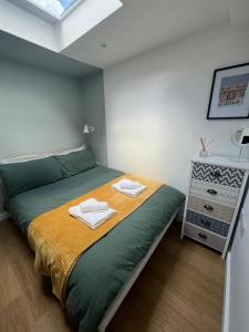 布莱顿霍夫Central ensuite guest unit with free on-street parking的一间卧室配有一张床,上面有两条毛巾