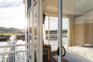 朗塞斯顿琵琶斯海港酒店的一间卧室设有享有水景的阳台