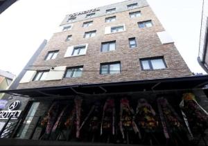 首尔Itaewon A One Hotel的商店顶部有窗户的高高的砖砌建筑