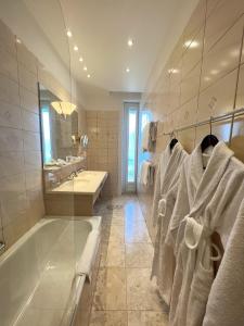 蒙特勒伊甸园宫奥拉克酒店的带浴缸、水槽和毛巾的浴室