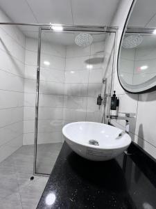迪拜布尔迪拜豪生大酒店的一间带玻璃淋浴和水槽的浴室