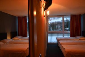 莱斯布里内特Hotel Les Rives Du Doubs的酒店客房设有两张床和窗户。