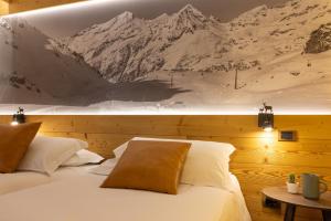 尚波吕克培缇图娜琳酒店的卧室配有两张床,墙上挂有山壁画